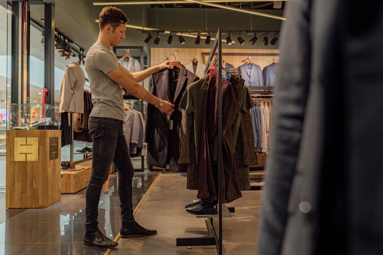 journey A man browsing stylish blazers in a modern clothing store, focusing on men's fashion.